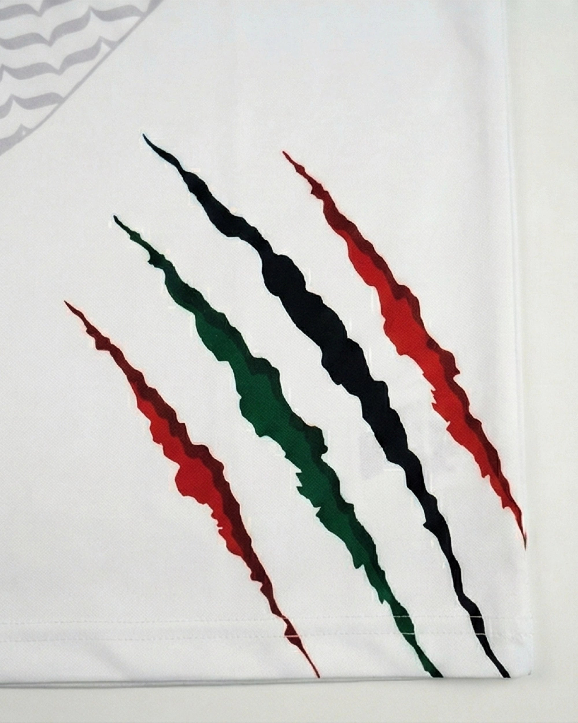 Détails du maillot Palestine Keffieh avec un design de griffures en rouge, vert, noir et blanc.