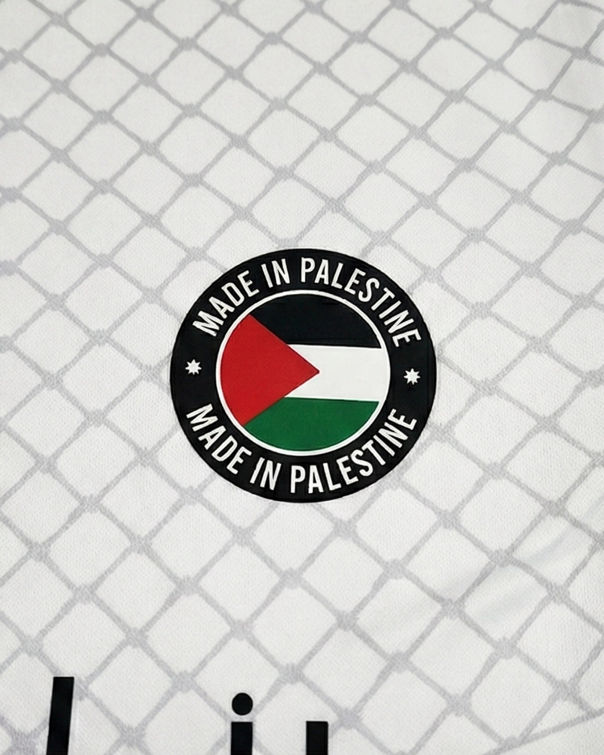 Détail du patch sur le maillot Palestine Keffieh, soulignant l'identité culturelle orientale.