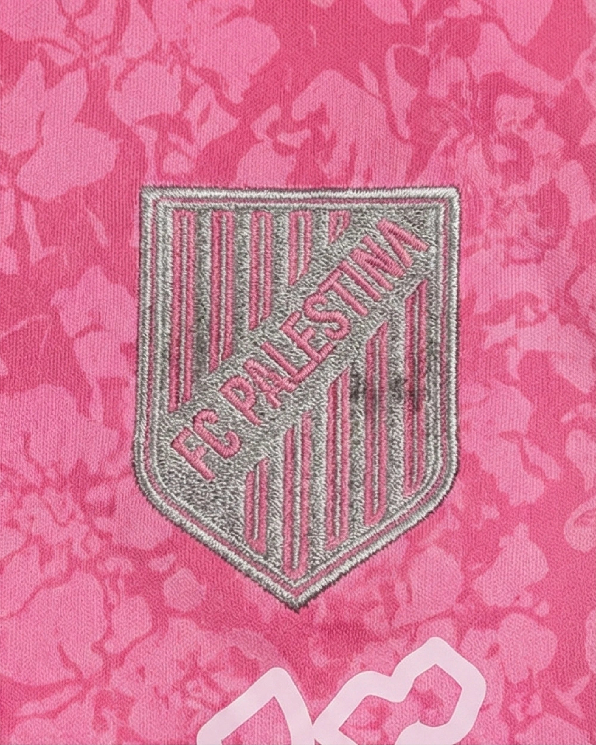 Logo du maillot Palestine noir et rose avec inscription FC Palestina sur fond floral.